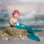 quelle est mignonne cette petite fille déguise en sirène . la photographe met tout en œuvre pour qu'elle passe un super moment et offre les plus beaux sourires pour faire plaisir as es parents