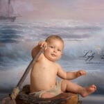 une superbe photo d un bébé en studio avec un petit short en laine sur le thème de la mer et de la peinture a l huile